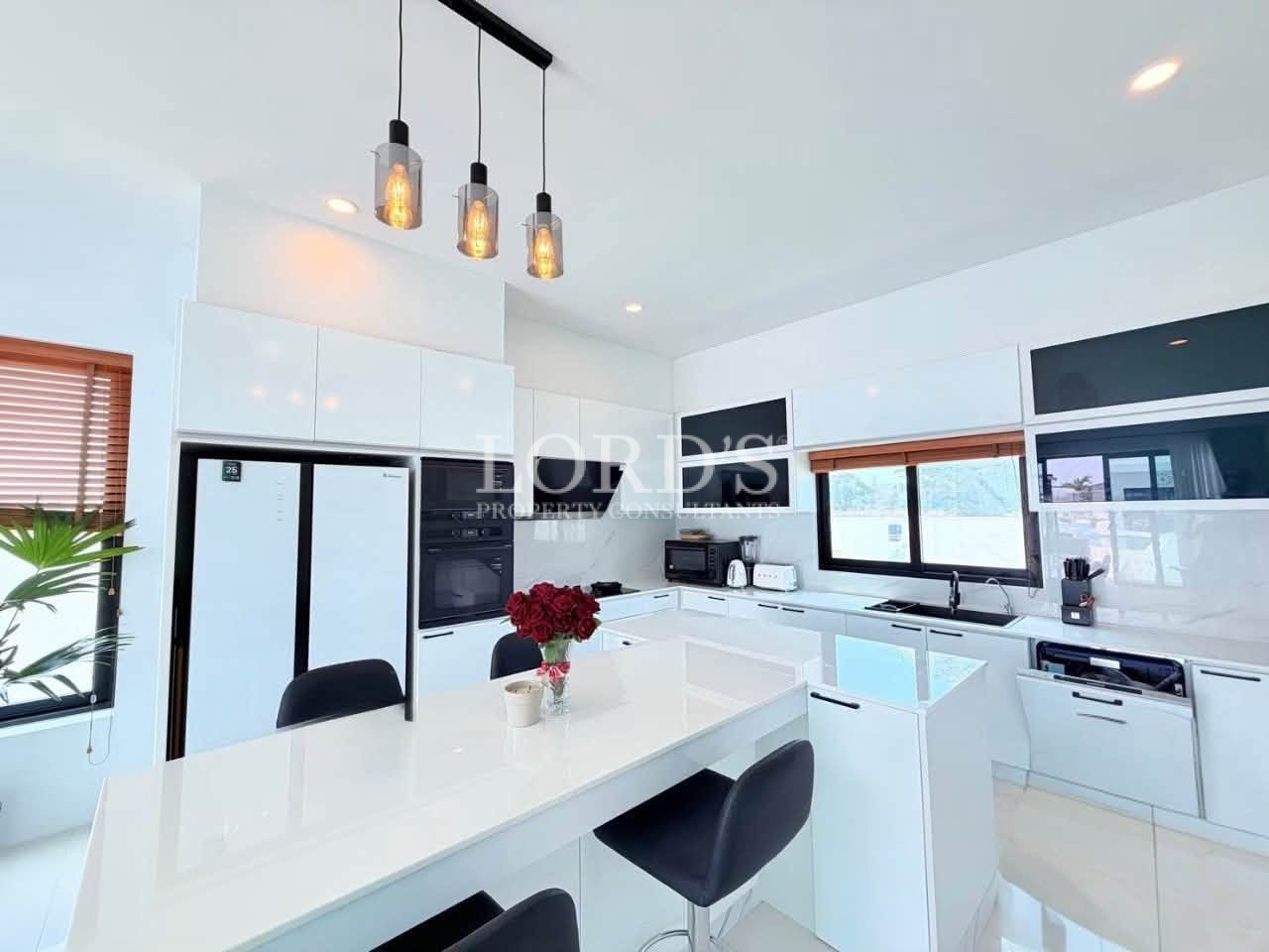 Modern white kitchen with large island and pendant lighting