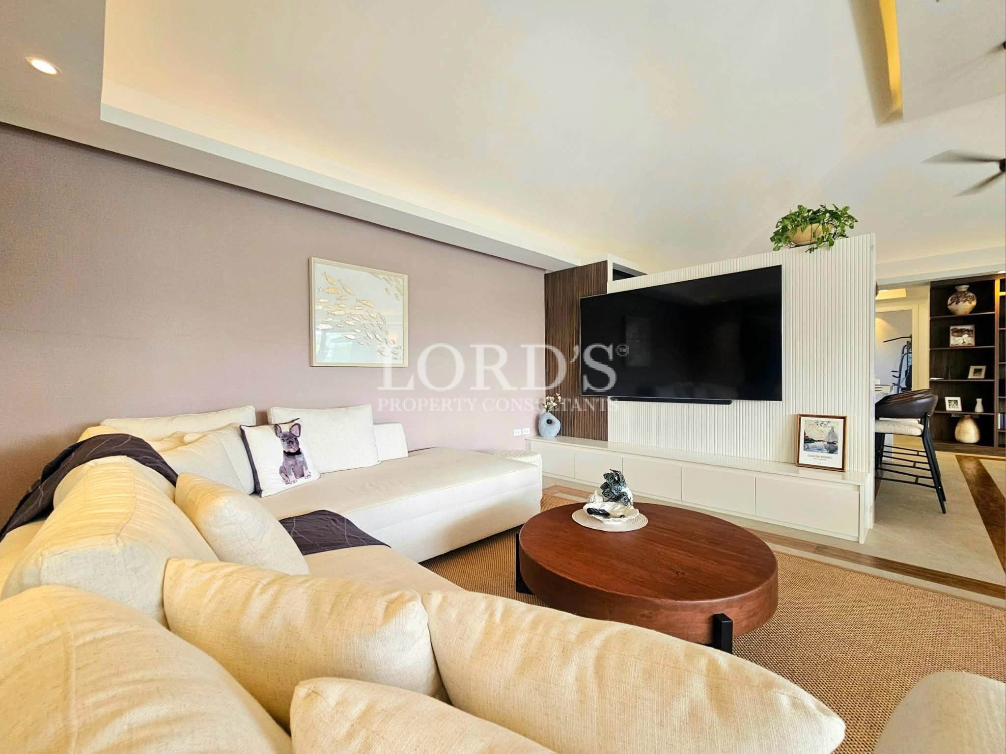 Luxury modern living room with a sectional sofa, wall-mounted TV, contemporary furnishings, and open-concept interior design