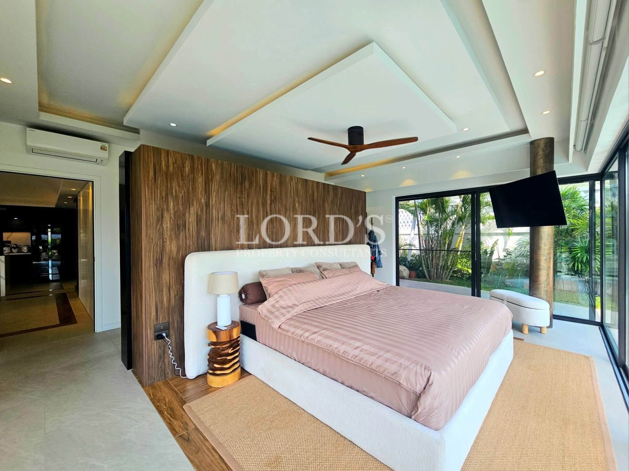 Luxury modern bedroom with a king-size bed, floor-to-ceiling windows, wood accent wall, and contemporary interior design