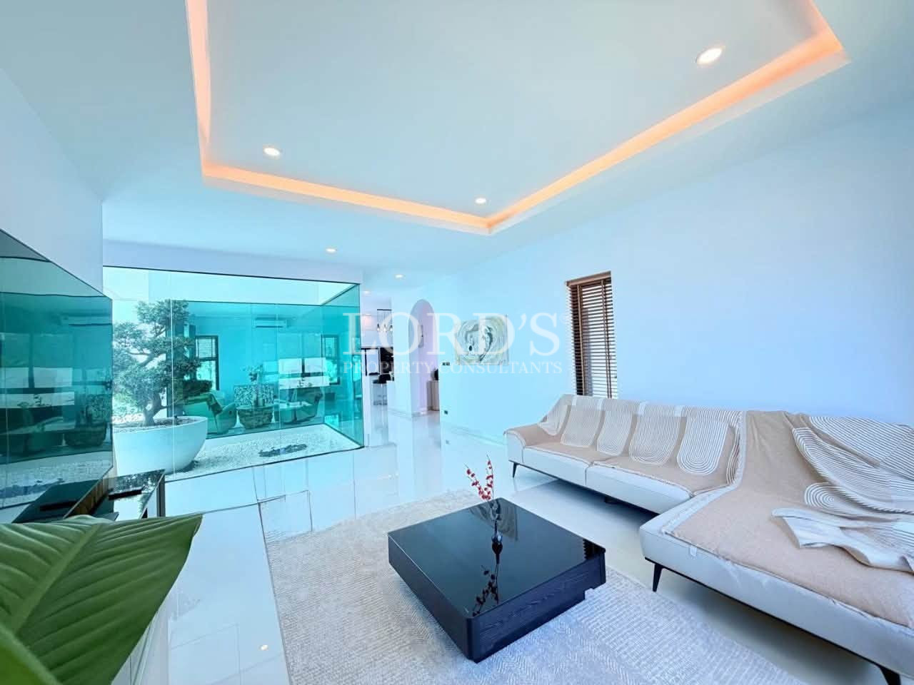 Modern living room with sectional sofa and glass-enclosed garden view