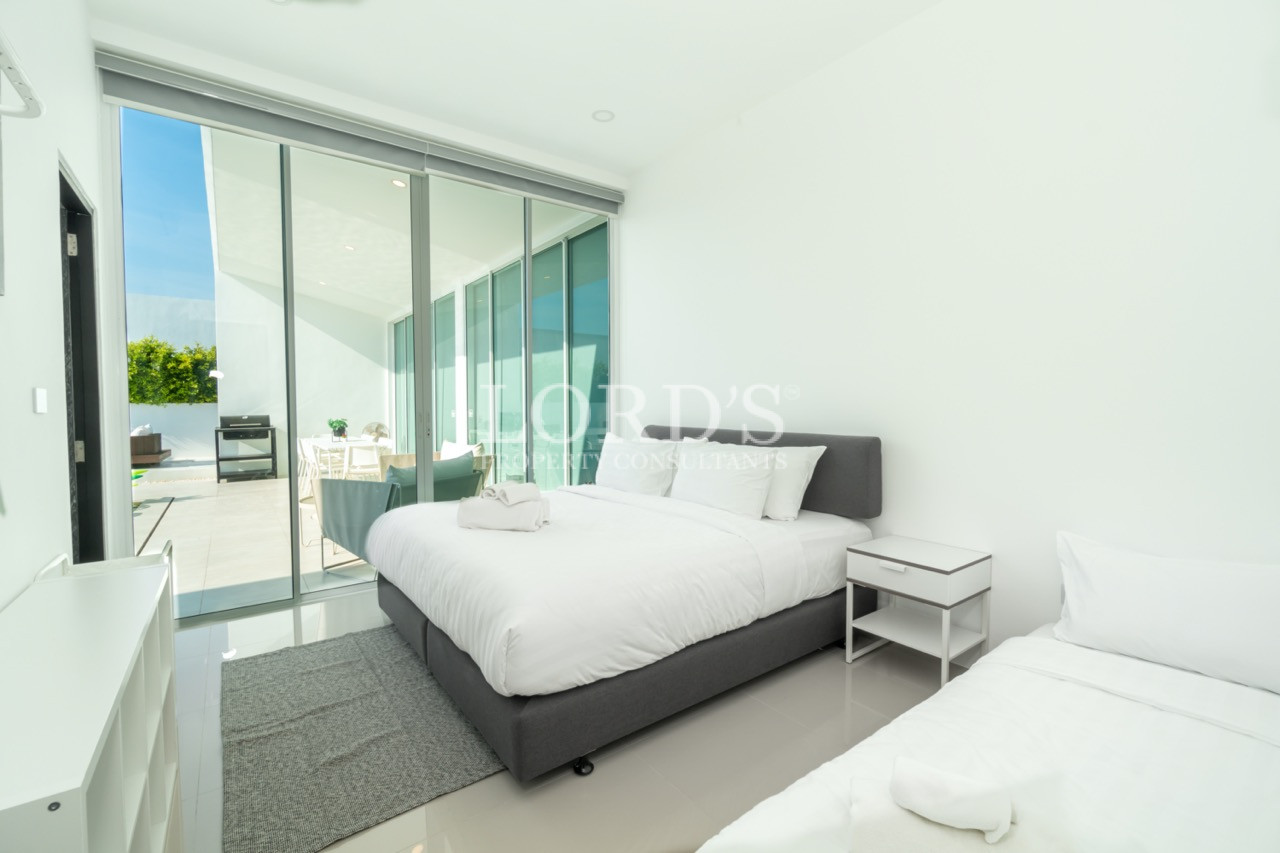 Modern bedroom with double and single beds overlooking an outdoor area