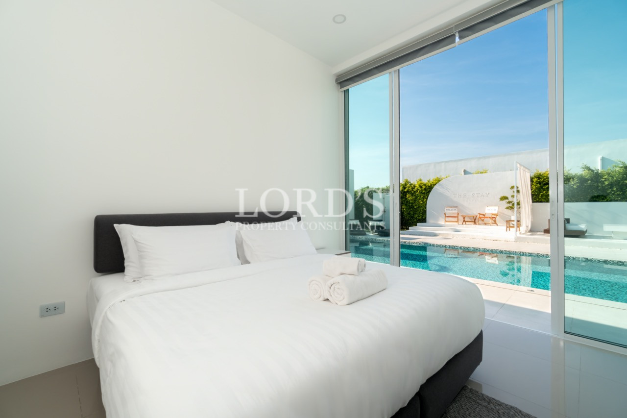 Modern bedroom with double bed overlooking a private swimming pool