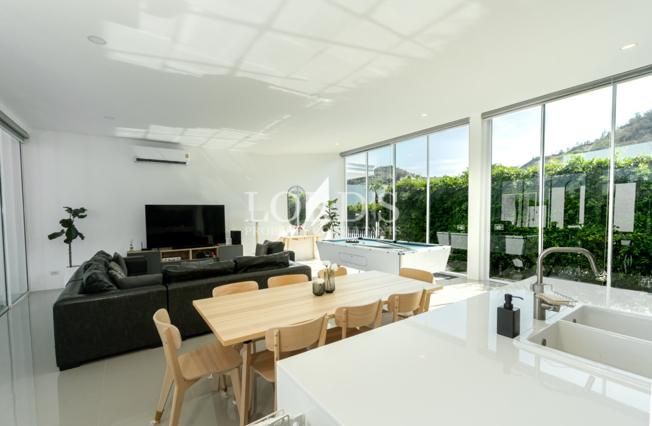 Modern open-plan living and dining area with large windows and contemporary furnishingsBright and spacious modern living and dining area