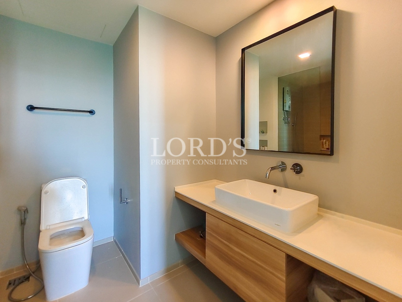 Modern apartment bathroom with floating vanity, vessel sink, large mirror, and contemporary minimalist design