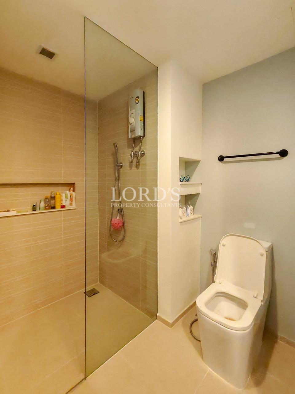 Modern apartment bathroom with glass-enclosed walk-in shower, contemporary toilet, and minimalist interior design