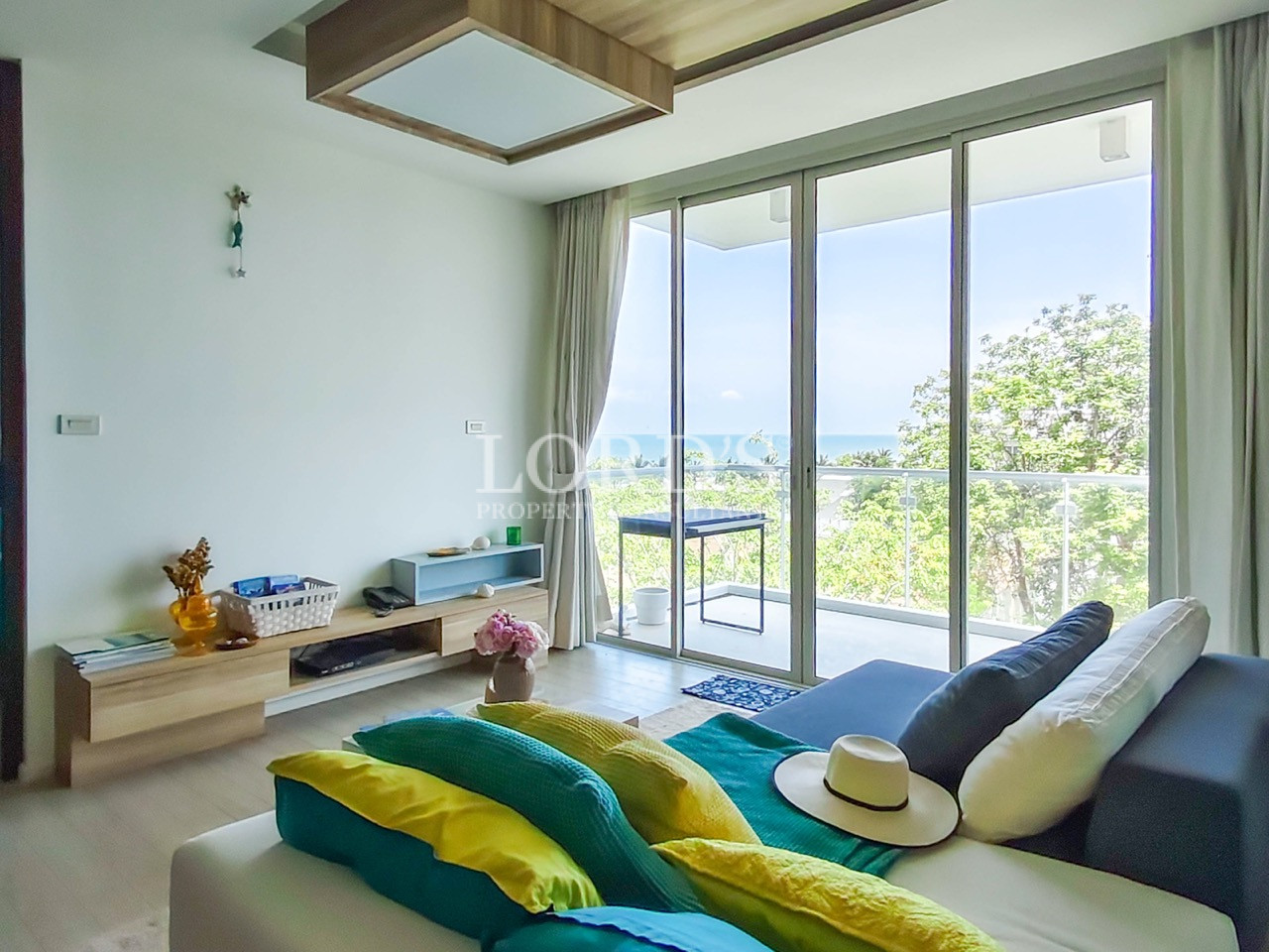 Modern apartment living room with floor-to-ceiling windows, private balcony, and contemporary furnishings
