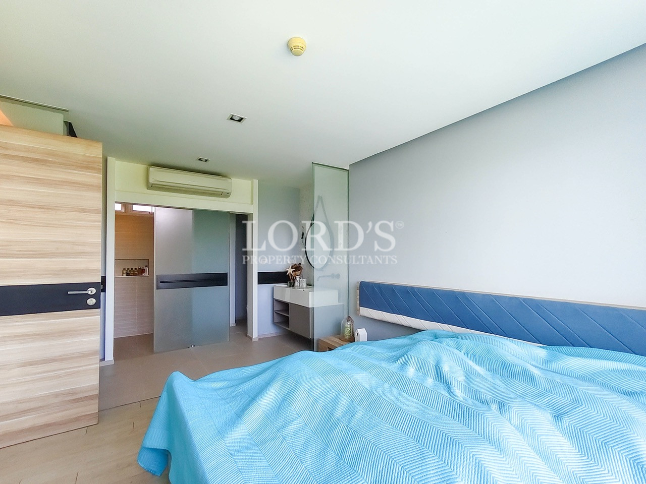 Modern apartment bedroom with upholstered bed, open vanity, and contemporary minimalist interior design
