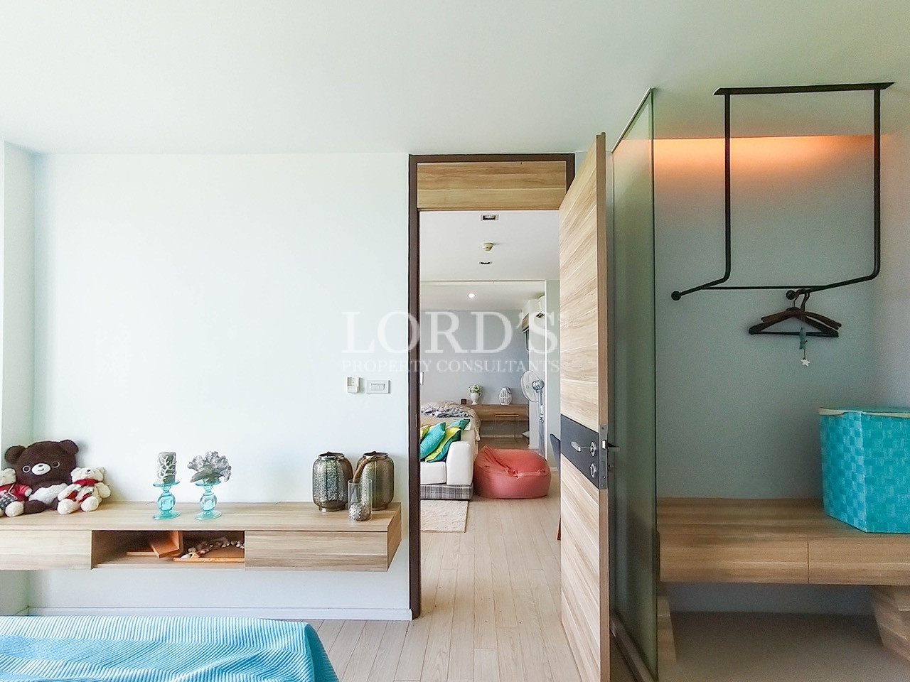Modern apartment bedroom with custom wardrobe, open closet, wood accents, and contemporary interior design
