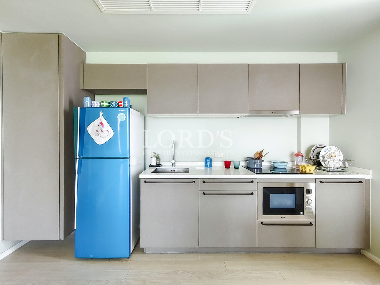 Modern apartment kitchen with sleek cabinetry, built-in appliances, refrigerator, and contemporary minimalist design