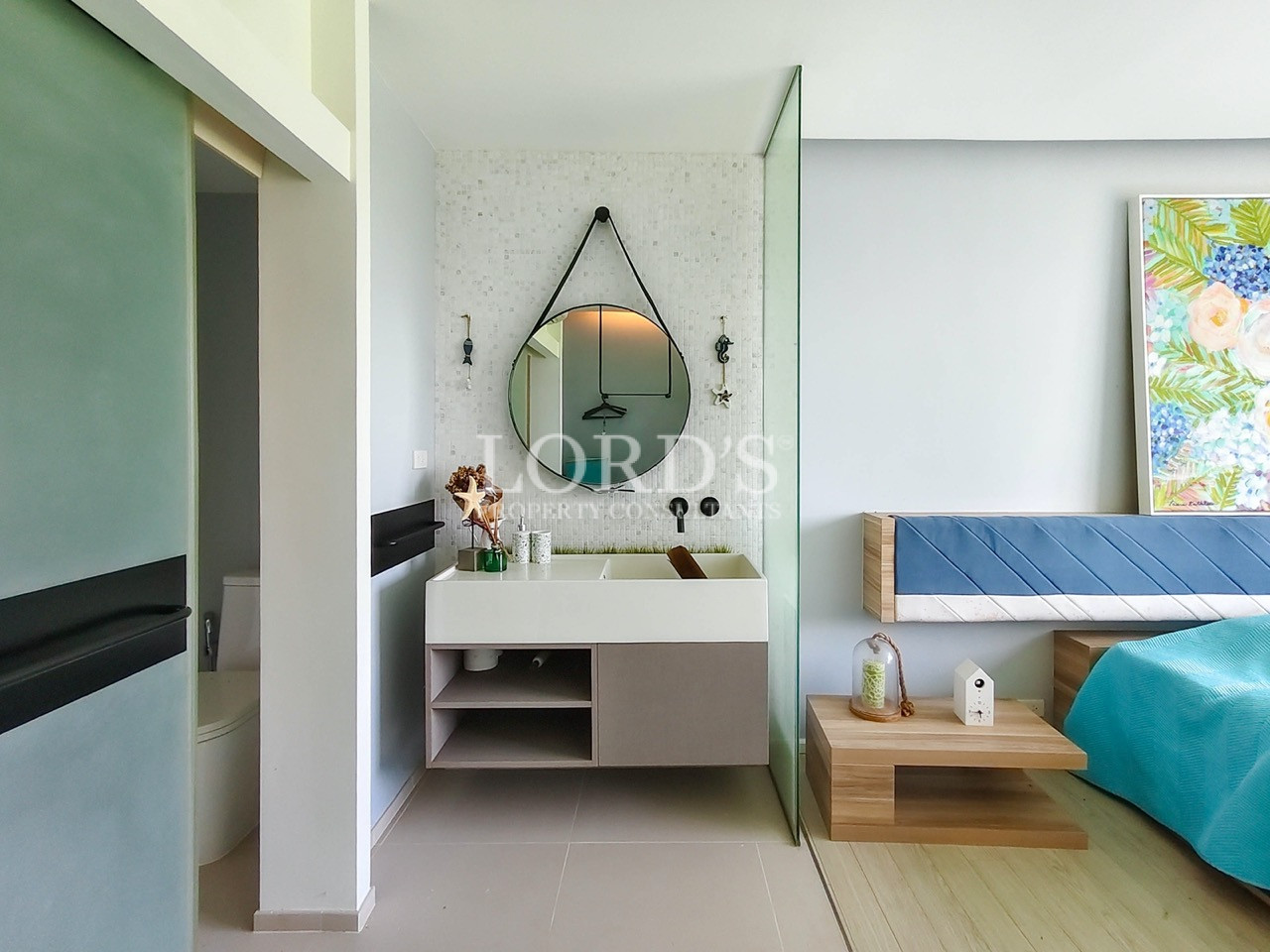 Modern bedroom with open vanity area, floating sink, glass partition, and contemporary interior design
