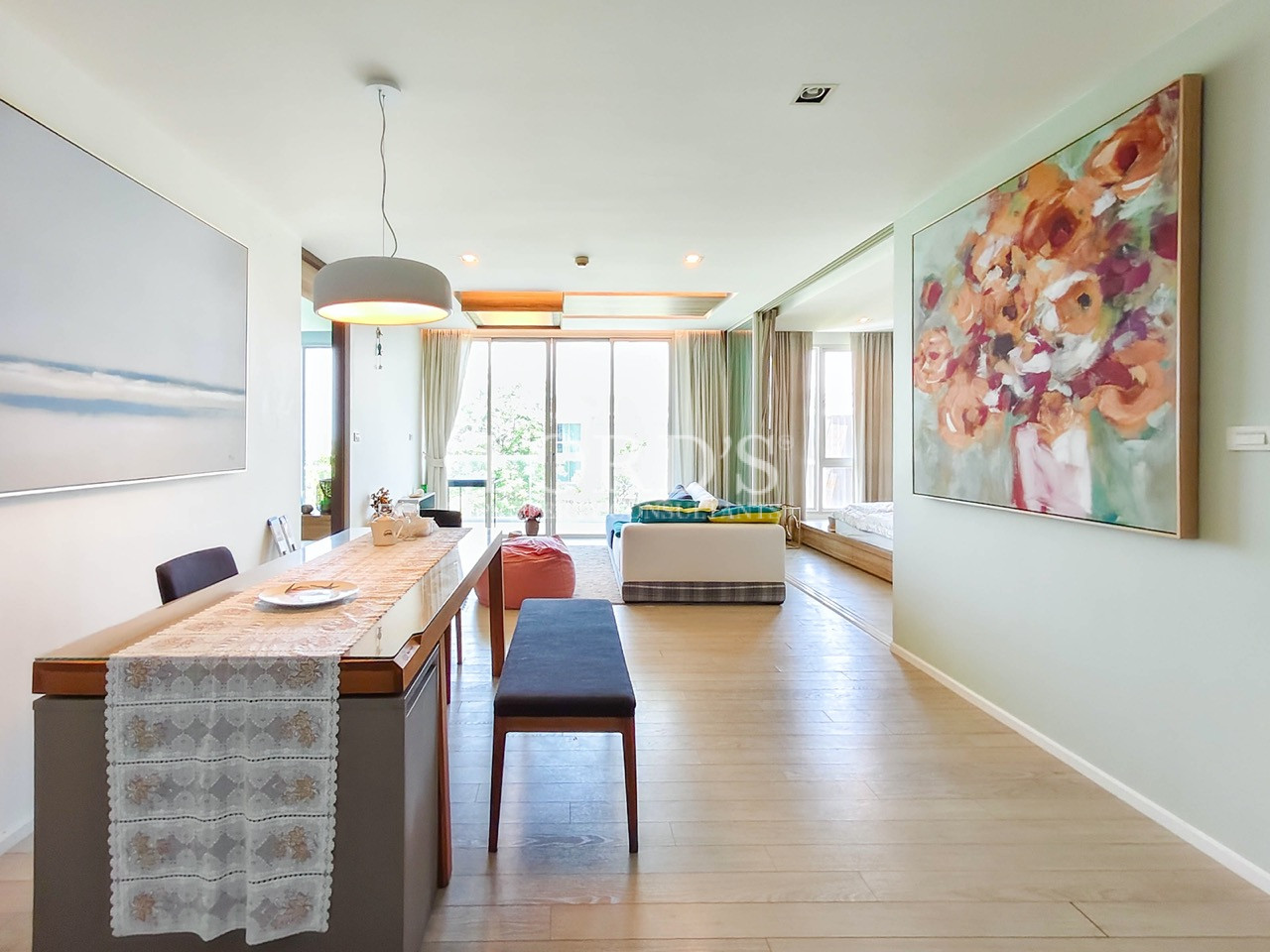 Modern open-plan apartment interior with dining area, living room, large windows, and contemporary décor