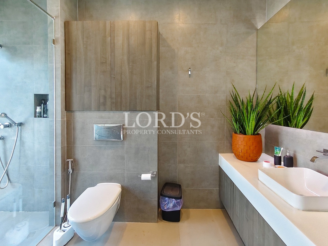 Luxury modern bathroom with frameless glass shower, floating vanity, vessel sink, and contemporary gray tile finishes