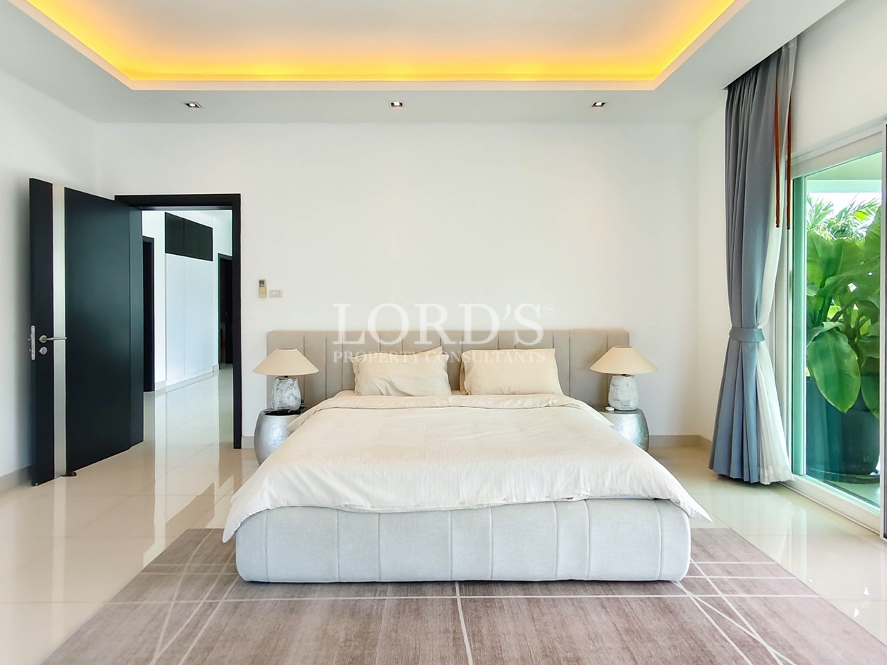 Luxury master bedroom with king-size bed, floor-to-ceiling windows, and contemporary minimalist design