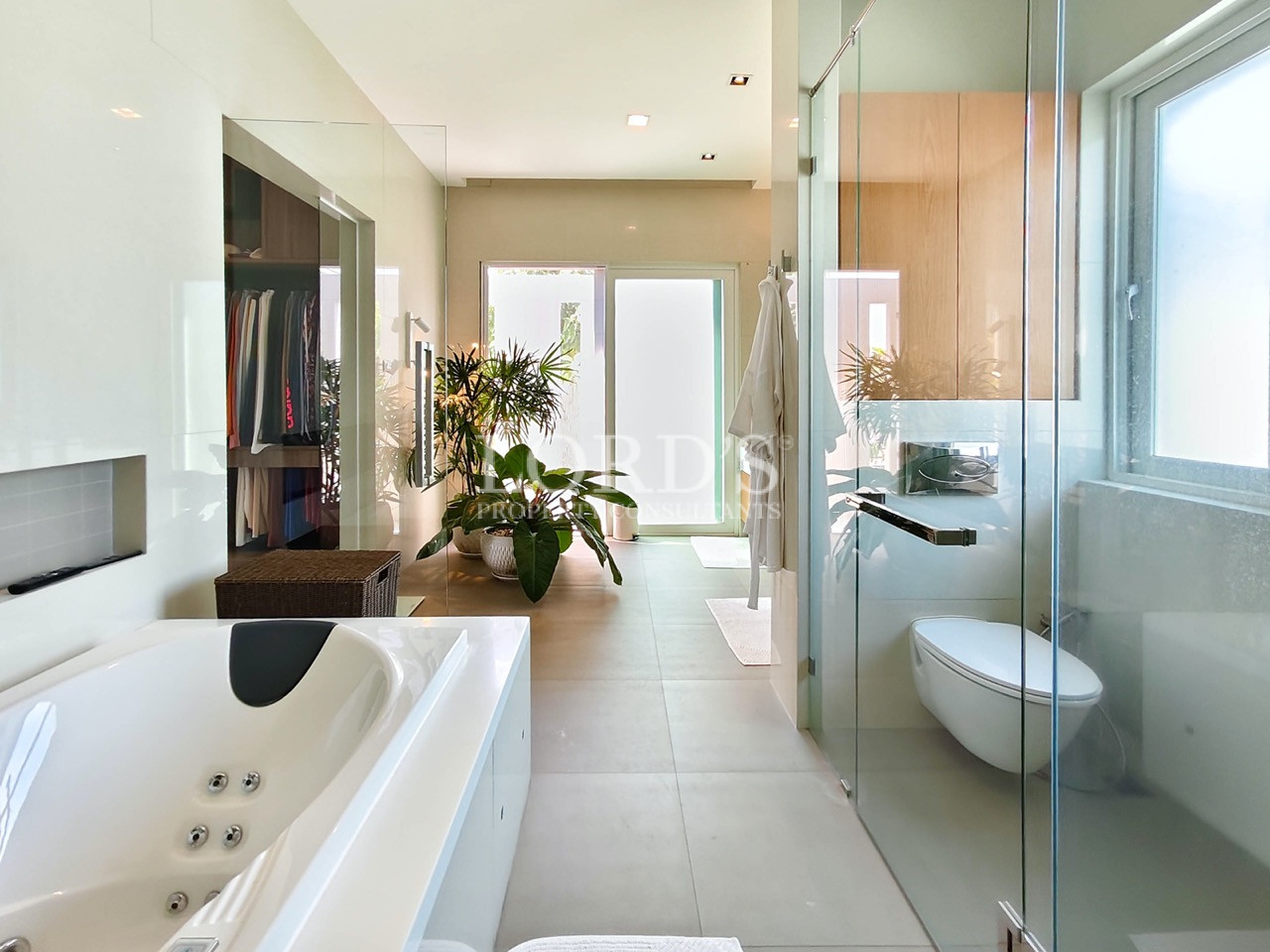 Luxury spa-inspired bathroom with soaking bathtub, glass walk-in shower, walk-in closet, and modern design