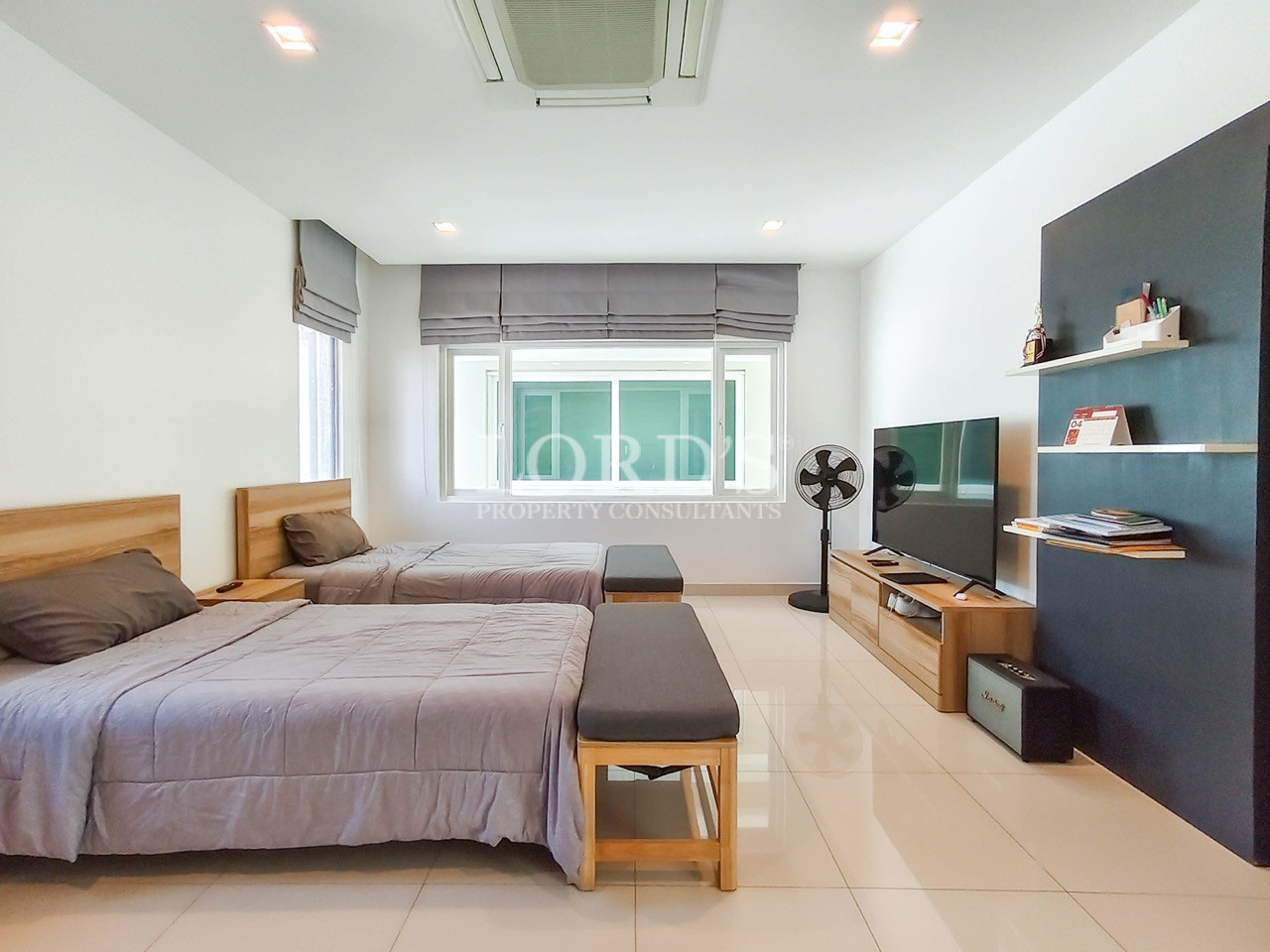 Luxury twin bedroom with two single beds, TV entertainment unit, large windows, and modern minimalist design