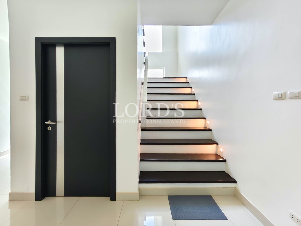 Modern floating staircase with wooden steps, LED step lighting, and contemporary interior design