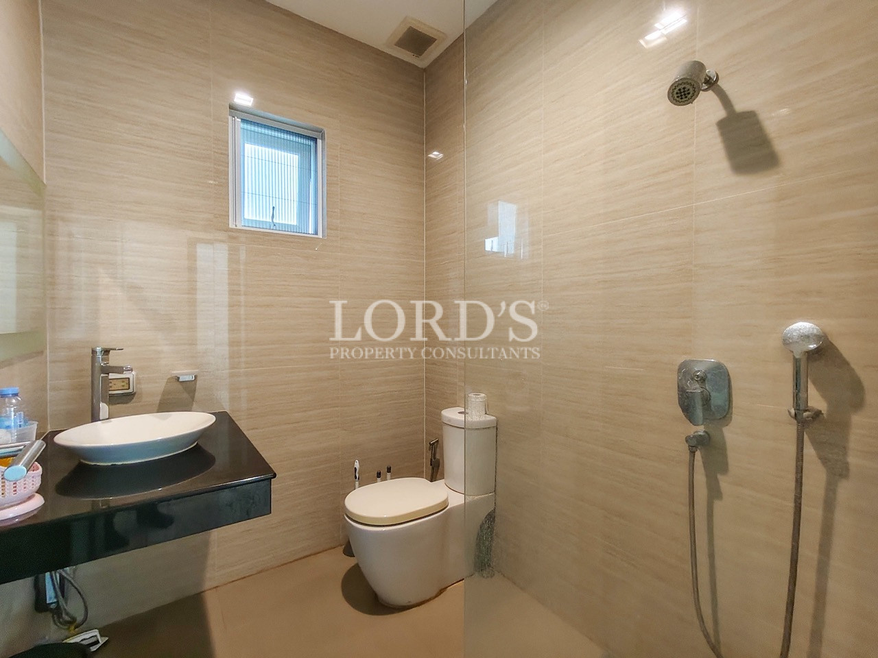 Modern luxury bathroom with walk-in shower, vessel sink, floating vanity, and contemporary tile finishes