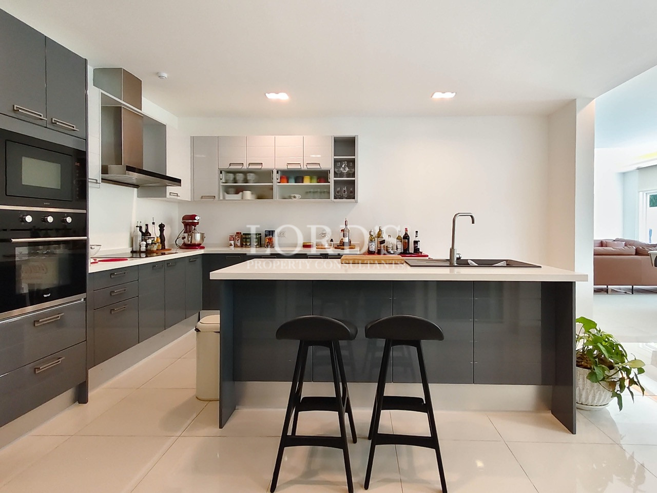 Modern luxury kitchen with island, breakfast bar, built-in appliances, and contemporary cabinetry