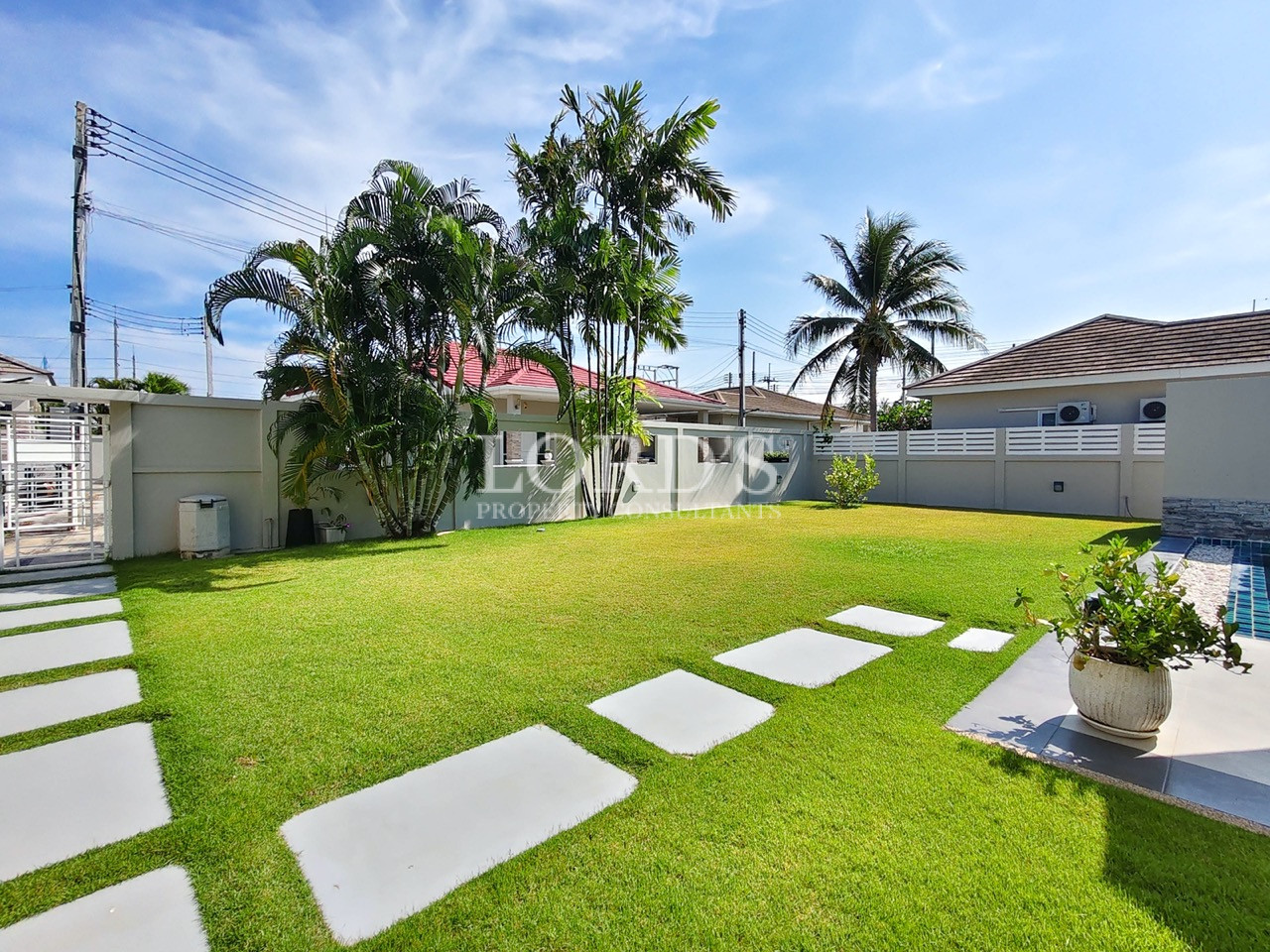 Luxury house exterior with tropical landscaping and palm trees
