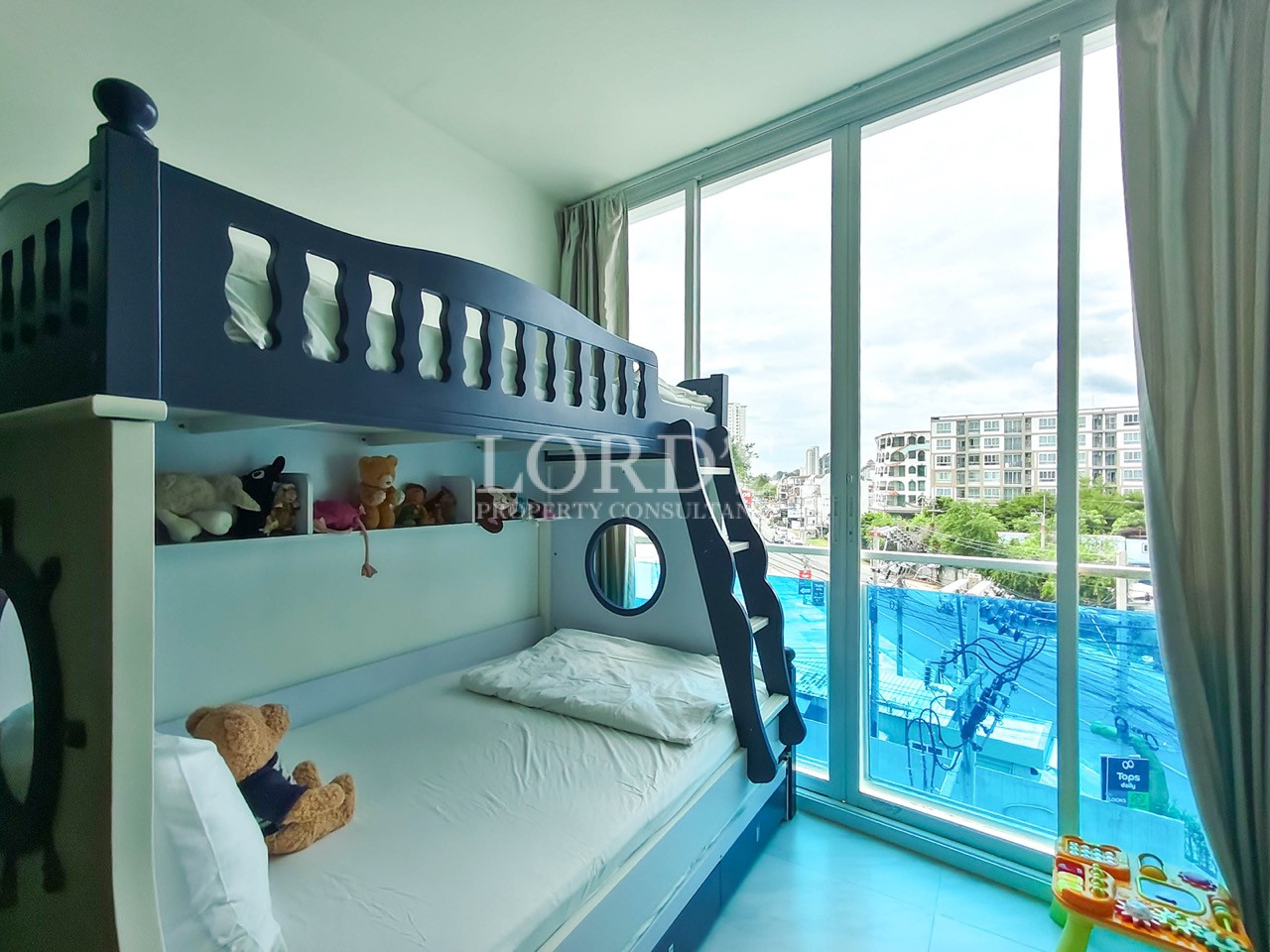 Kids' bedroom with bunk bed, large windows, pool view, and children's toys