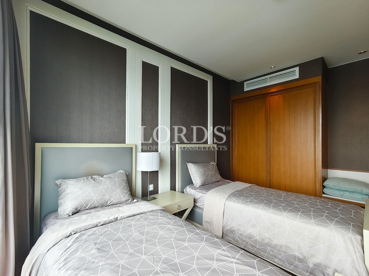 Modern twin bedroom with two single beds and wooden wardrobe