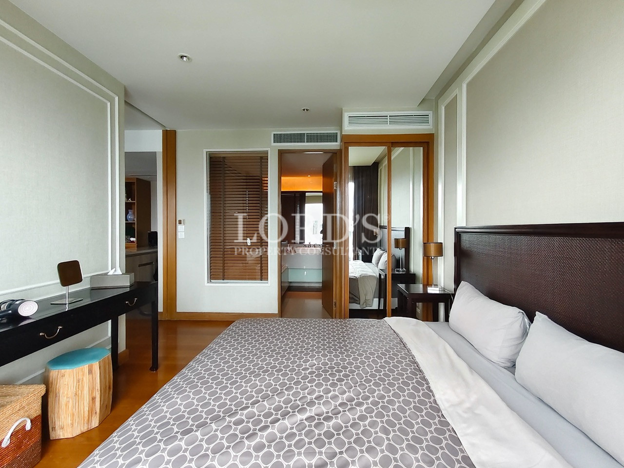 Modern bedroom with king-size bed, desk, and mirrored wardrobe