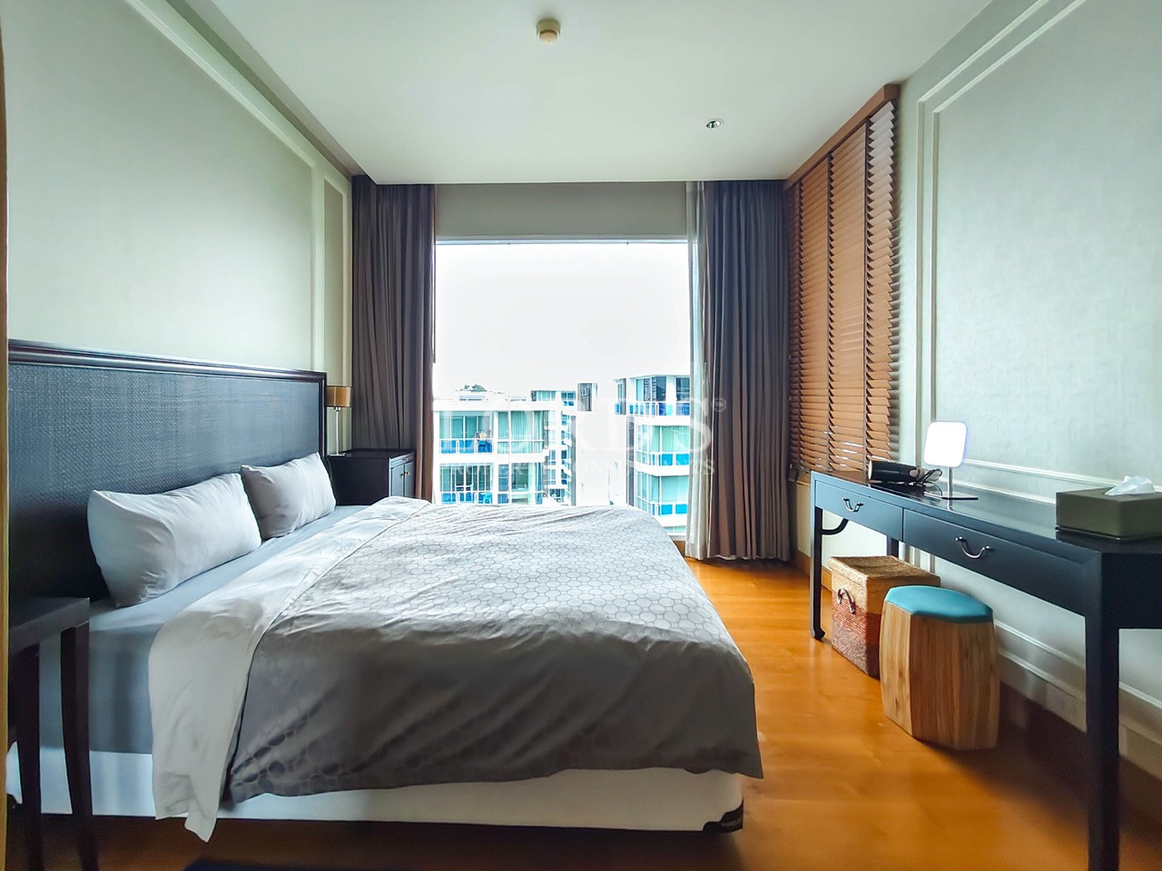 Modern bedroom with king-size bed, large window, and writing desk
