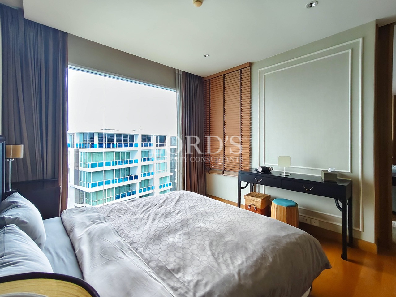 Modern bedroom with large window, desk, and wooden flooring