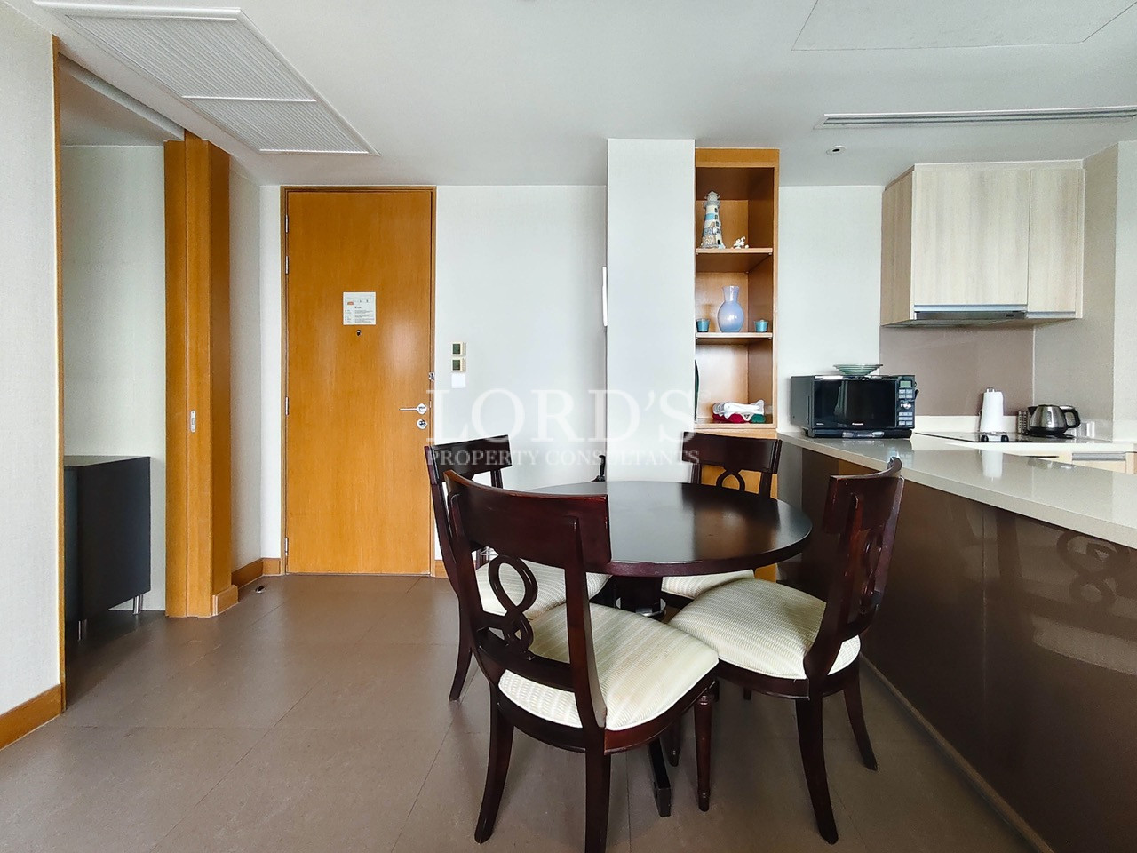 Modern dining area with round table, chairs, and open kitchen