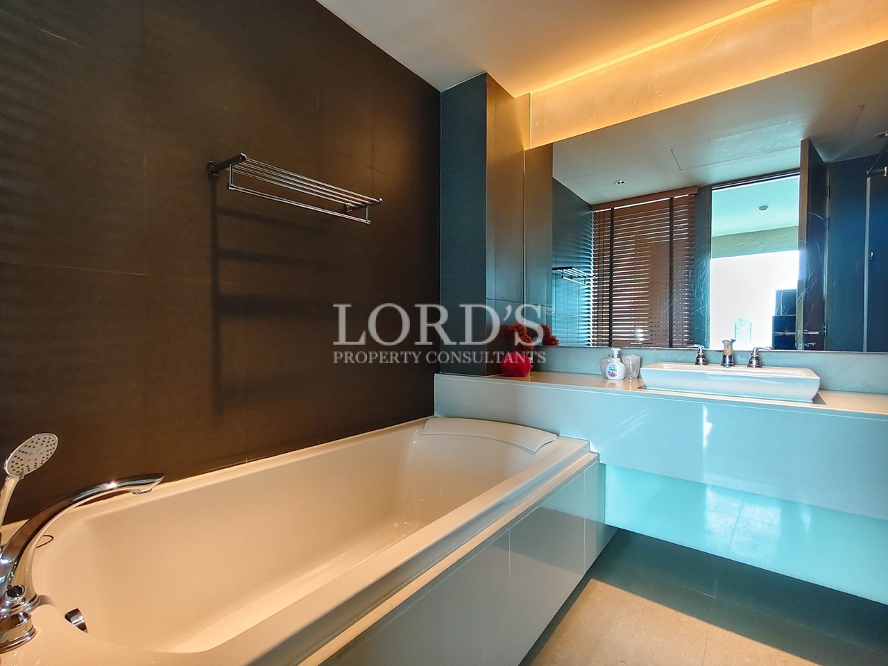 Modern bathroom with built-in bathtub, vanity, and large mirror