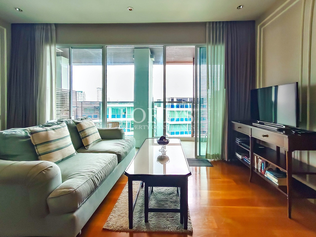 Modern living room with sofa, TV, and balcony view