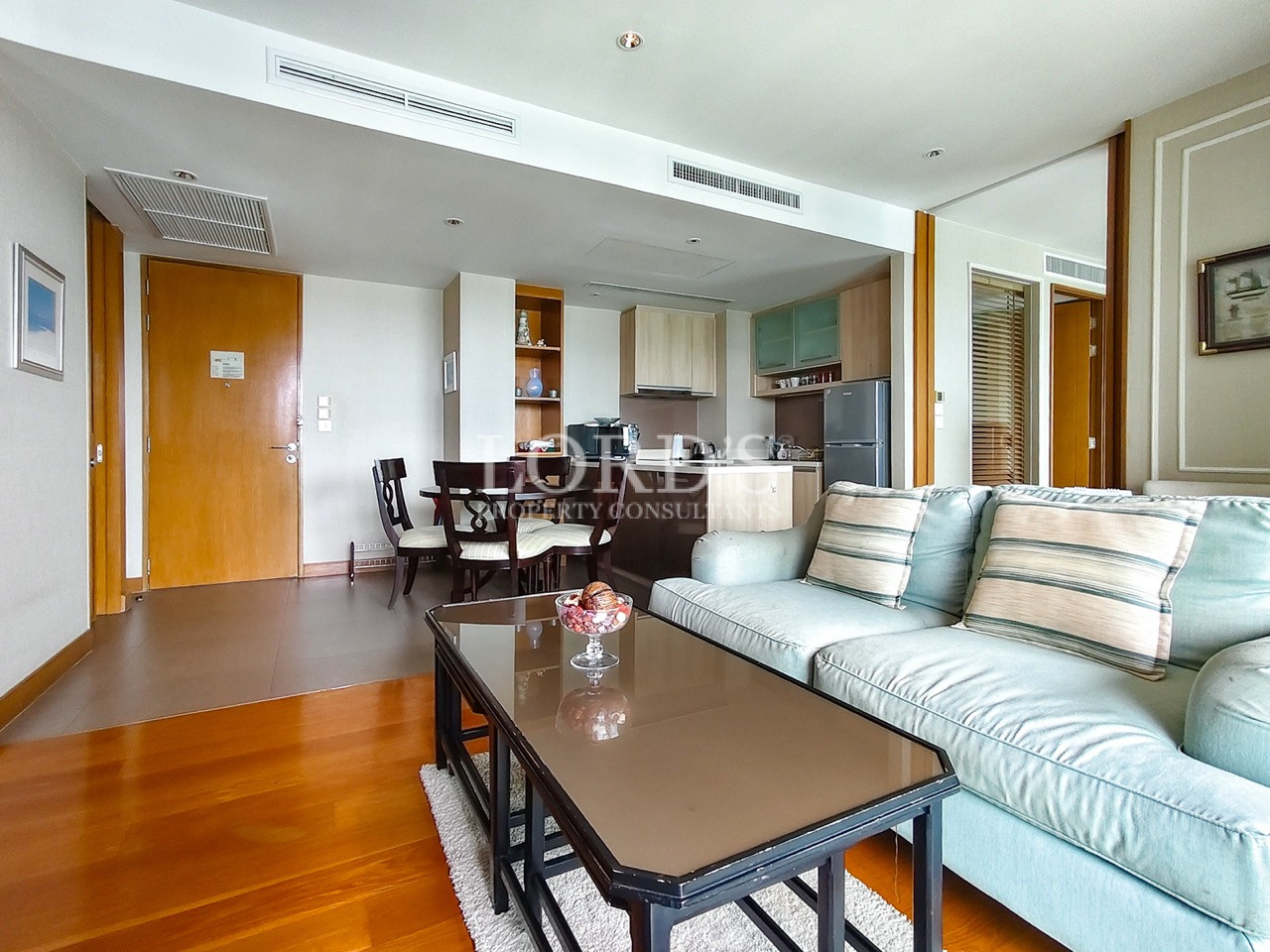 Modern living room with sofa, dining area, and open-plan kitchen
