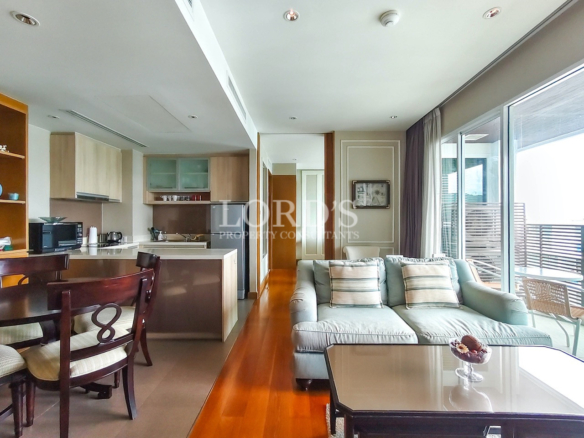 Modern open-plan living room with kitchen, dining area, and private balcony