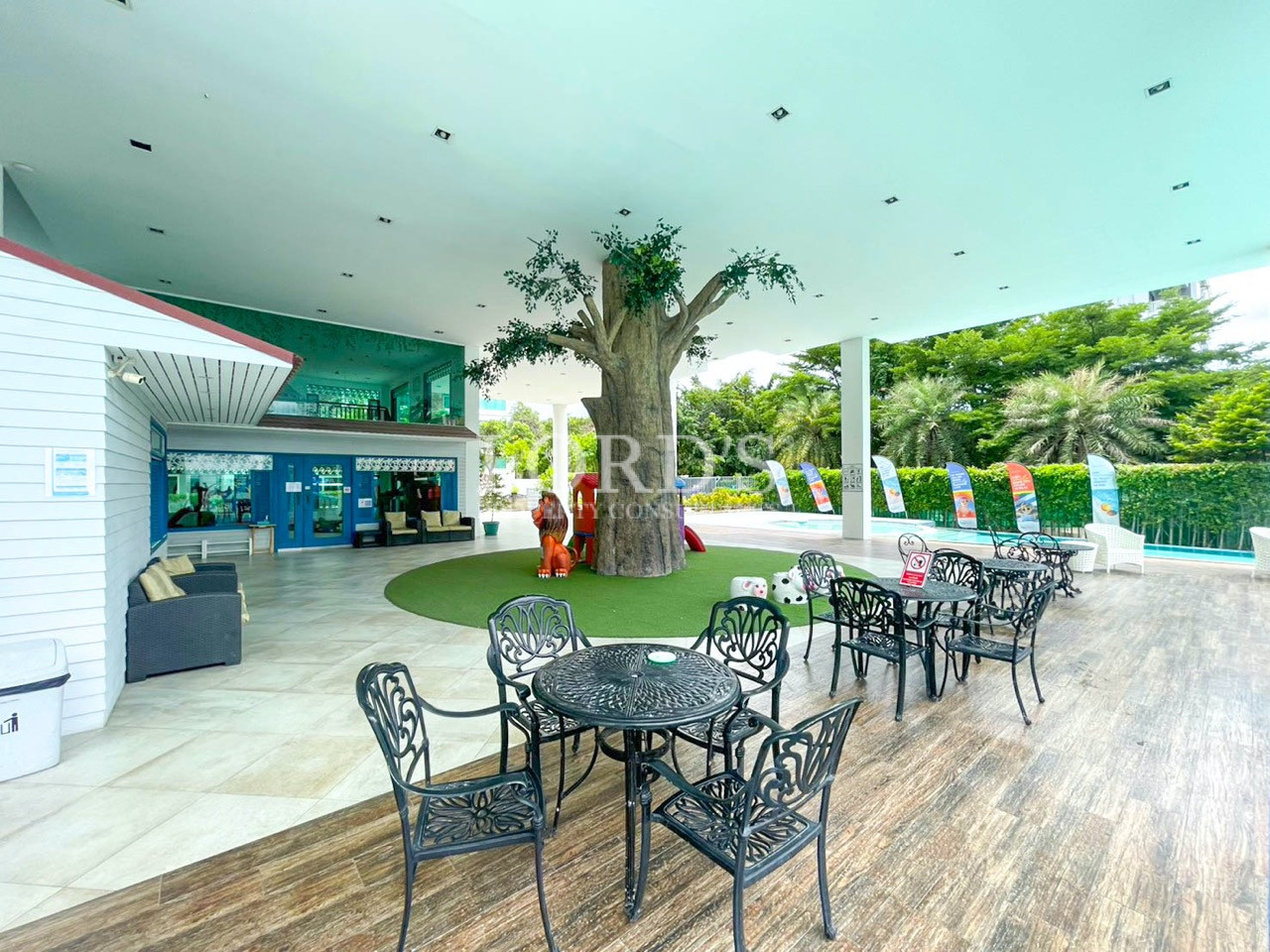 Outdoor seating area with a swimming pool, garden, and decorative tree
