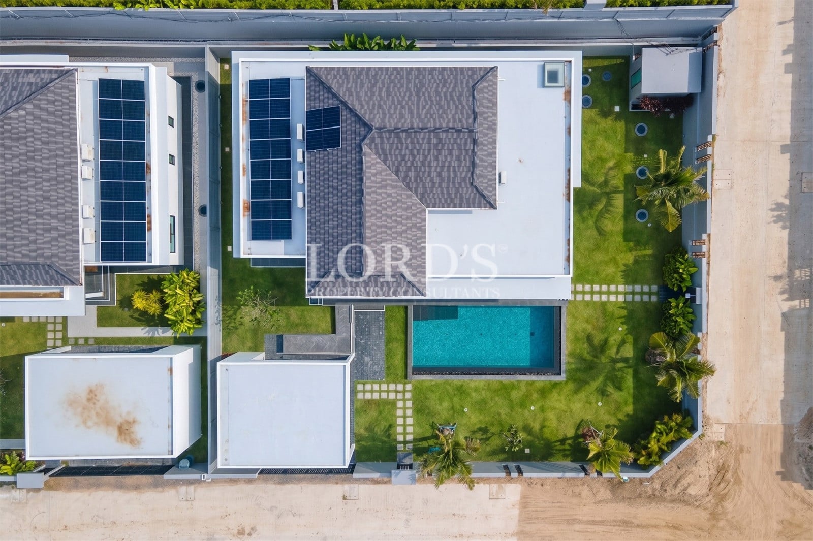 Top-down aerial view of a modern luxury villa with private pool and landscaped garden