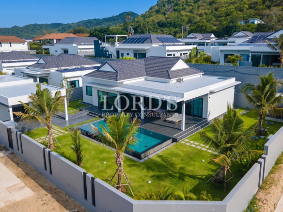 Aerial view of a modern luxury villa with private swimming pool and landscaped garden