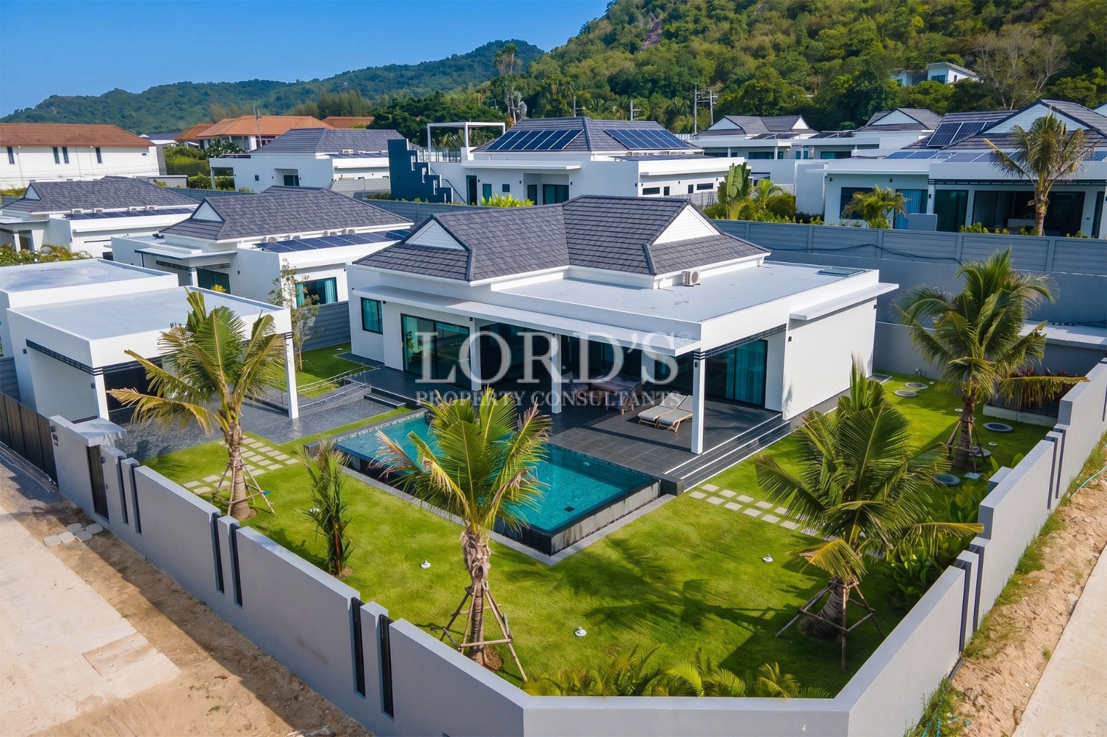Aerial view of a modern luxury villa with private swimming pool and landscaped garden