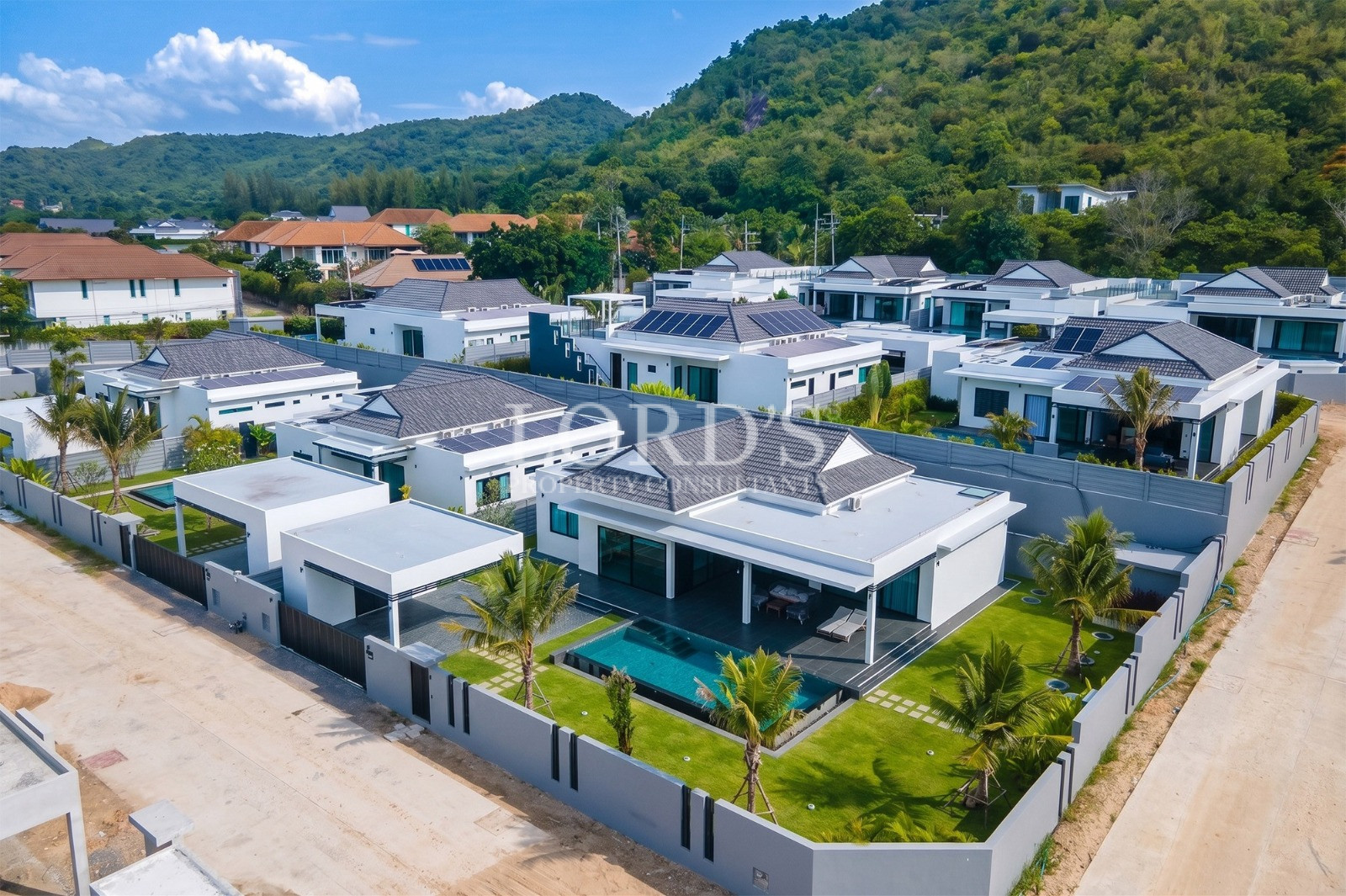 Aerial view of a modern luxury villa with private pool and landscaped garden