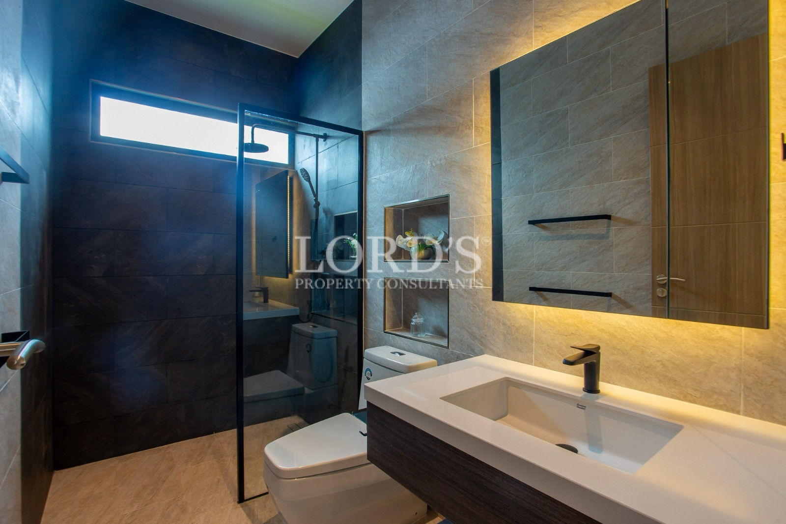 Modern luxury bathroom with glass shower and illuminated vanity