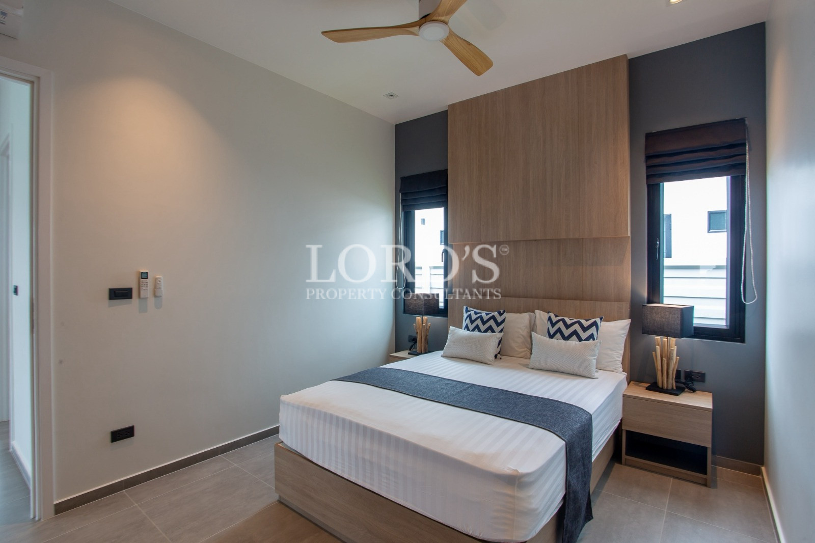 Modern minimalist bedroom with wooden feature wall and bedside tables
