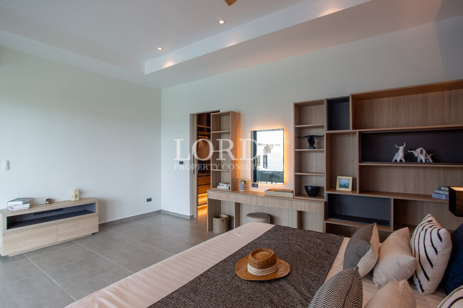 Modern luxury bedroom with built-in shelving and vanity area