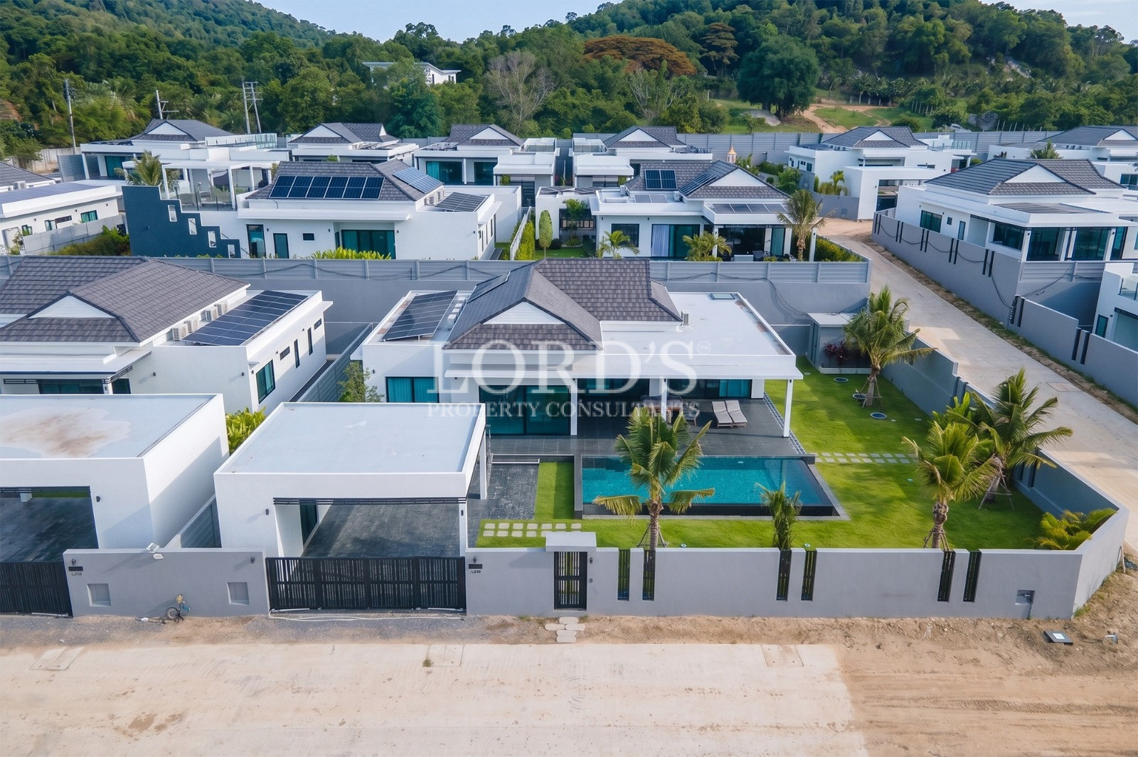 Aerial view of a modern luxury villa with private pool and landscaped garden