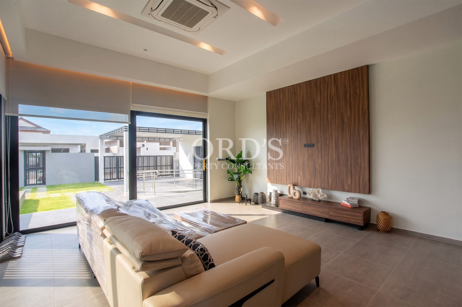 Modern luxury living room with large windows and wood feature wall