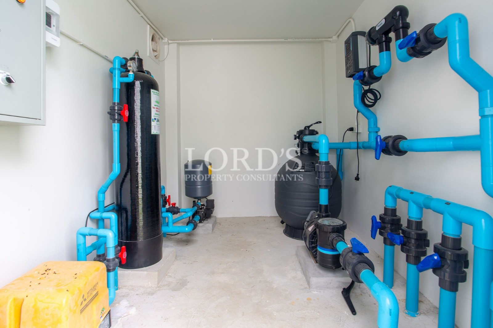 Private swimming pool filtration and pump system with blue PVC piping