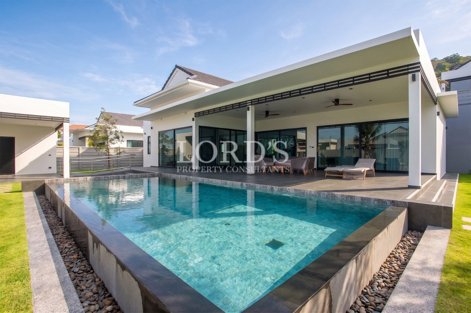 Modern luxury villa with private swimming pool, covered terrace, and landscaped garden