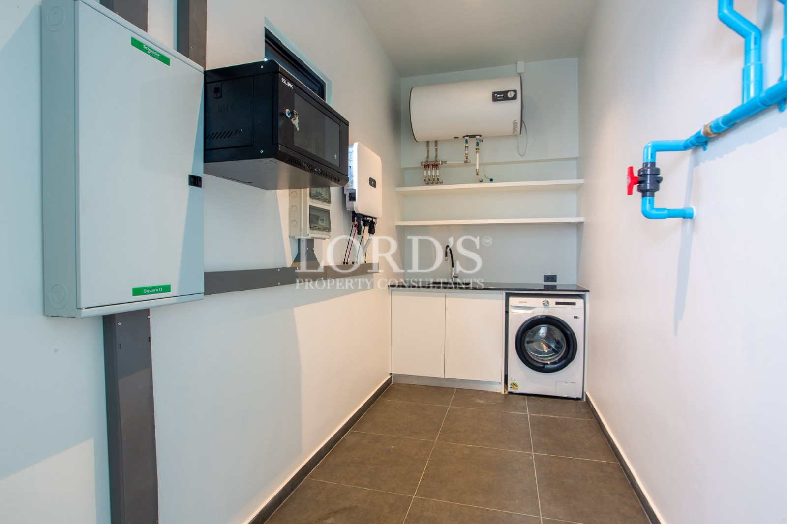 Modern utility room with water heater, washing machine, and electrical systems
