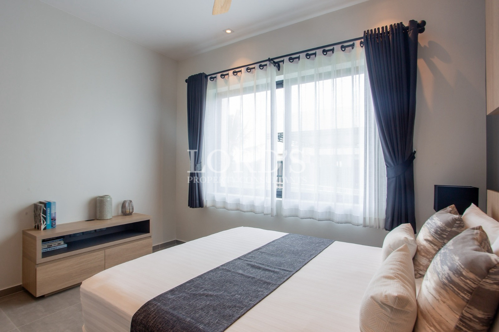 Modern bedroom with large window and elegant dark curtains