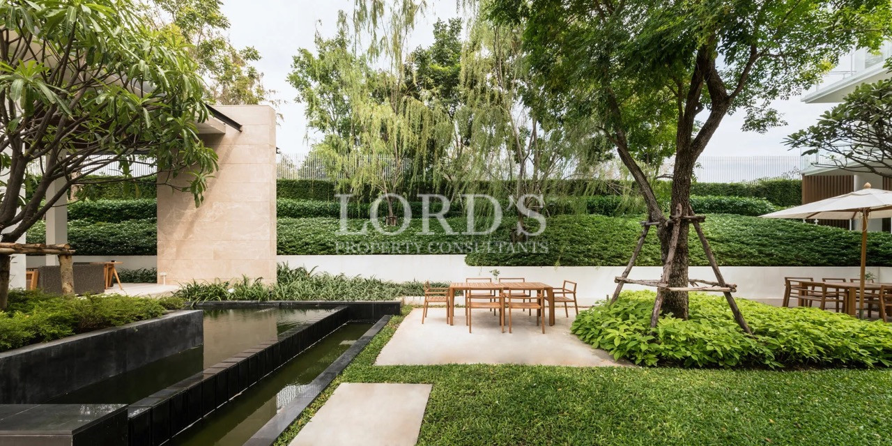 Luxury landscaped courtyard with outdoor seating, reflecting pool, mature trees, and modern residential community amenities