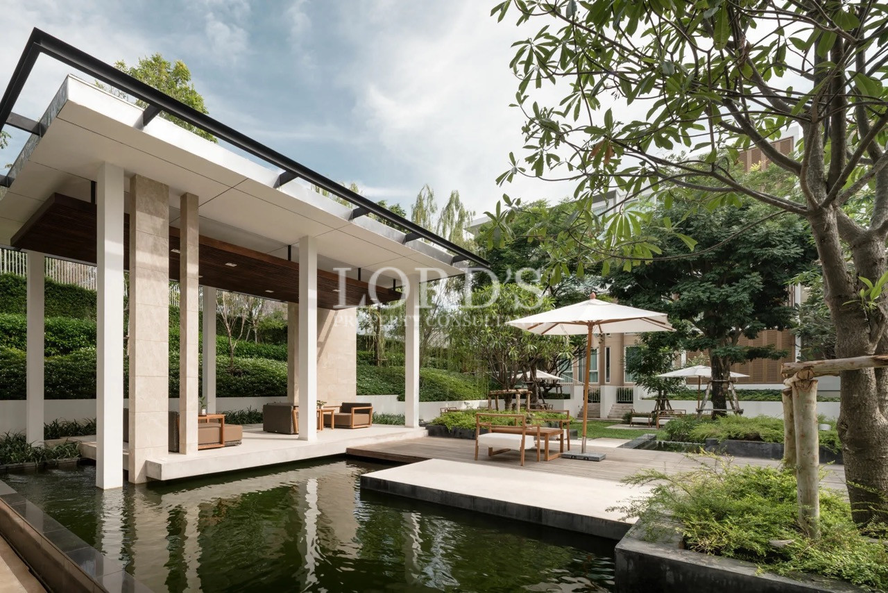 Luxury residential courtyard with a modern pavilion, reflecting pool, landscaped gardens, and outdoor seating