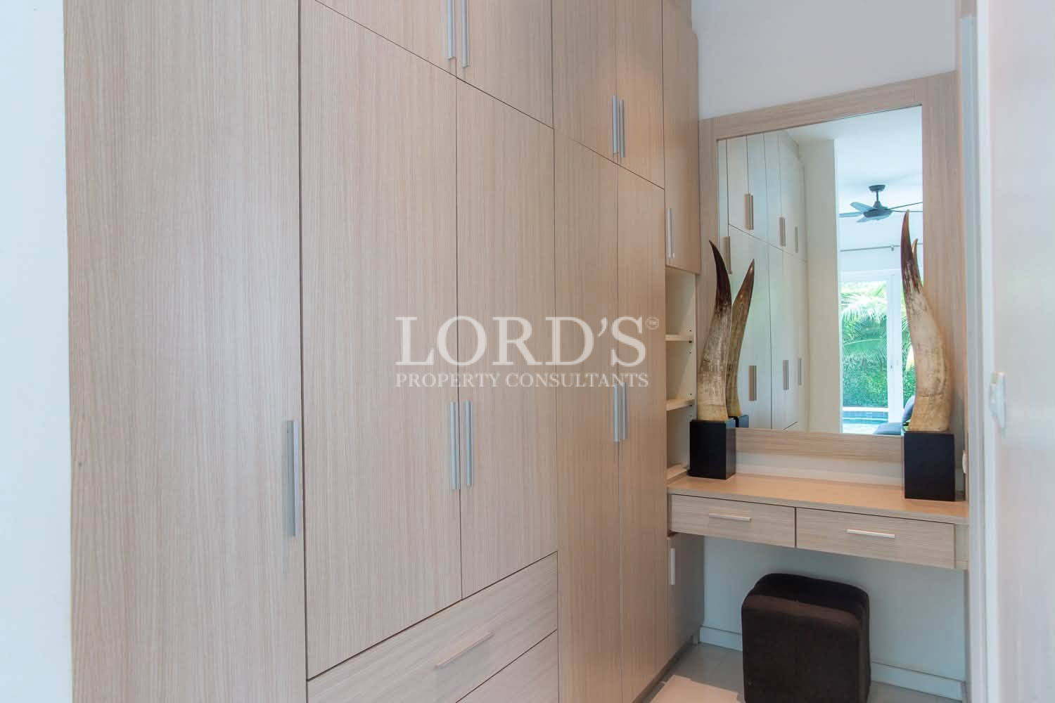 Built-in wooden wardrobe with storage cabinets in a modern bedroom